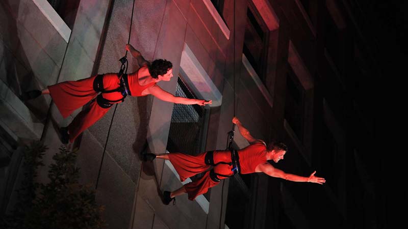 Two theater students repelling off a set